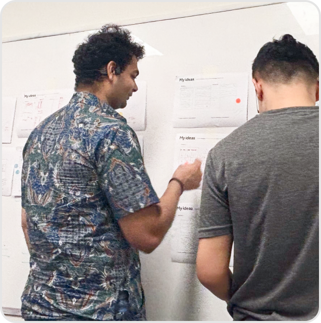 Two people reviewing ideas on the wall